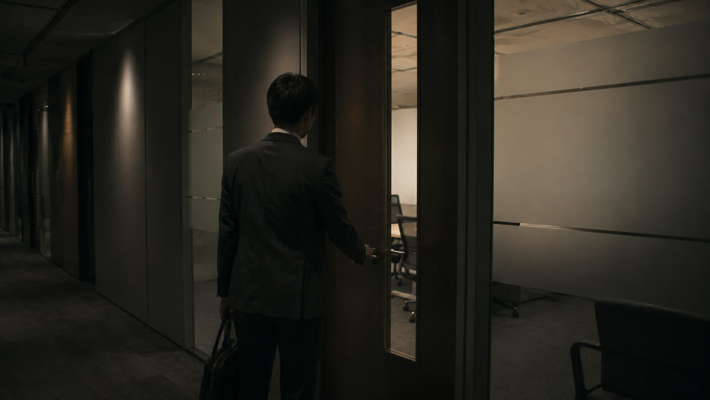会議室のドアノブに手をかけ、これから入ろうとしている社員の後ろ姿